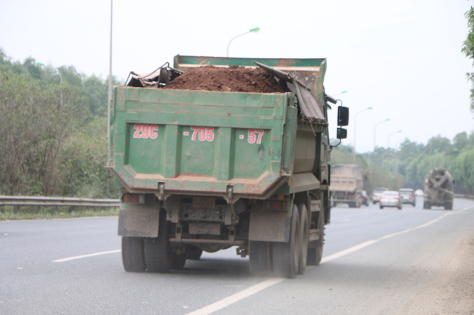 Chiếc xe chở đất lưu thông trên Đại lộ Thăng Long không được phủ bạt, ngang nhiên chở cao hơn thành thùng.