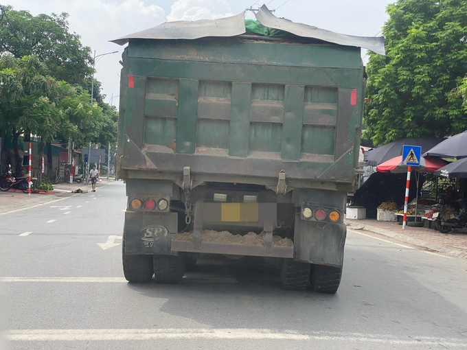 Không những chở có ngọn, chiếc xe này còn có dấu hiệu cơi nới phần thùng sau, một khối lượng cát vương trên cản sau rơi ra đường