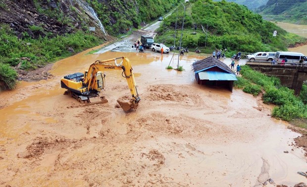 Máy múc được huy động để san gạt bùn, đất, đá bị sạt lở tại bản Nà Lếch, xã Chiềng Lao, huyện Mường La.