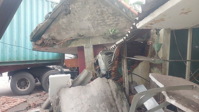 Một phần ngôi nhà bị đổ sập khiến tài xế xe container mắc kẹt trong cabin.