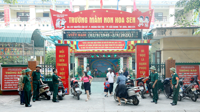 Các thành viên tổ tự quản CCB tổ dân phố Tiền Giang ( TP. Bắc Giang) hướng dẫn phụ huynh bảo đảm ATGT trước cổng trường Mầm non Hoa Sen