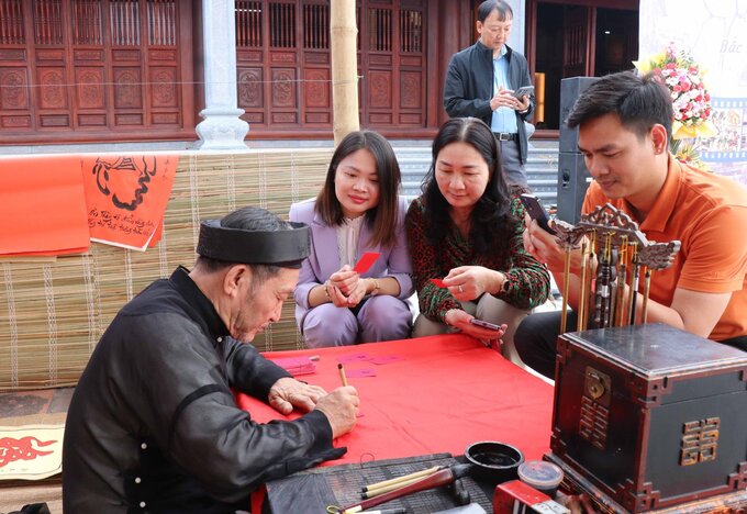 Du khách tìm hiểu tranh dân gian Đông Hồ tại chợ tranh.