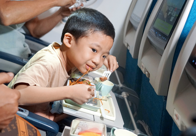 Hình ảnh đáng yêu của một em bé đang thưởng thức suất ăn nóng trên chuyến bay.