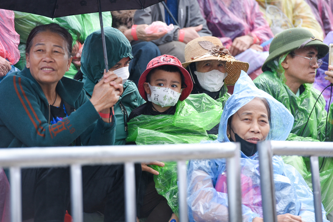 Nhiều người dân, du khách cùng các em nhỏ đội mưa xem những tác tiết mục văn nghệ đặc sắc tại lễ hội.