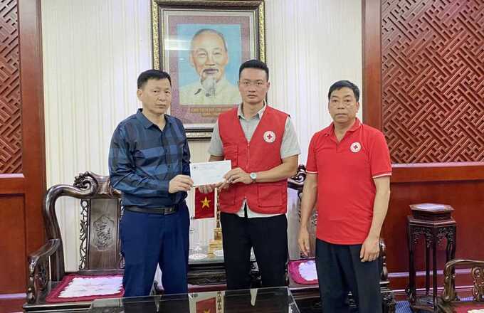 Ông Nguyễn Tuấn Anh, Phó Chủ tịch Hội Chữ thập đỏ tỉnh, trao tiền hỗ trợ các nạn nhân bị tai nạn lao động cho đại diện Công ty Than Quang Hanh. Ảnh: Dương Trường
