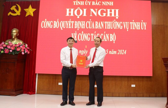 Phó Bí thư Thường trực Tỉnh ủy, Chủ tịch HĐND tỉnh Bắc Ninh Nguyễn Quốc Chung (phải) trao Quyết định của Ban Thường vụ Tỉnh ủy Bắc Ninh cho ông Nguyễn Đình Lợi.
