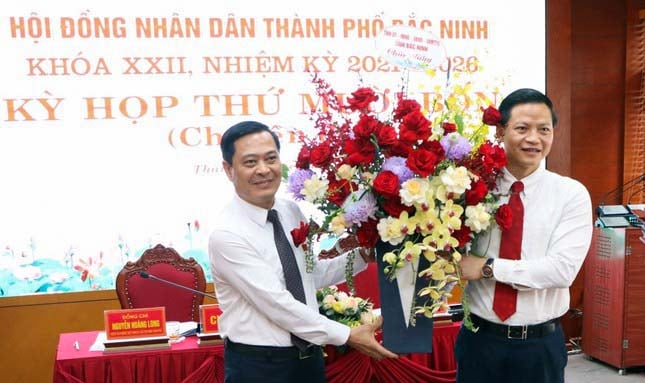 Phó Chủ tịch Thường trực UBND tỉnh Bắc Ninh Vương Quốc Tuấn (bên phải) tặng hoa chúc mừng ông Nguyễn Mạnh Hiếu.