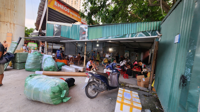 Bên trong 'bến cóc', hàng trăm hành khách ngồi chờ xe; trong khi đó, các xe tải thi nhau ra vào gửi hàng.