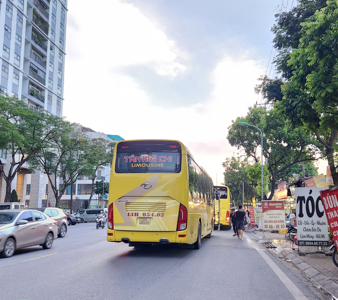 Xe khách Tân Kim Chi dàn hàng dưới lòng đường, vô tư đón khách tại bến cóc mới trên phố Trần Thủ Độ, quận Hoàng Mai. Ảnh chụp chiều ngày 4/7.