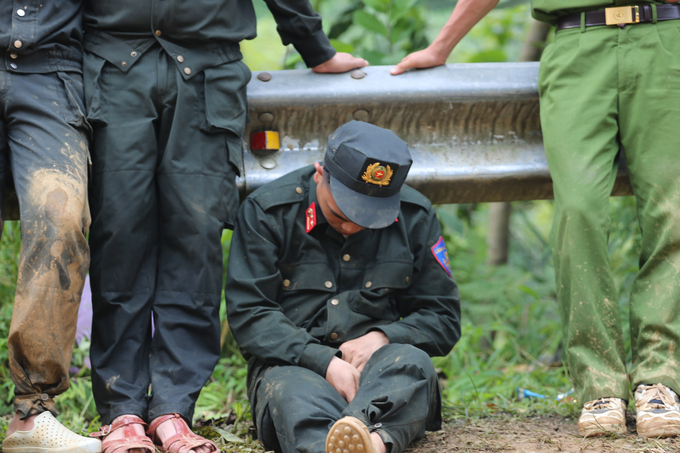 Một chiến sĩ Cảnh sát cơ động tranh thủ chợp mắt dưới hộ lan ven đường sau thời gian dài tìm kiếm nạn nhân