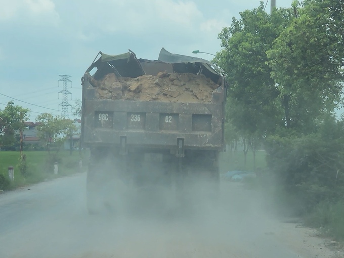 Đây là một trong những nguyên nhân chính dẫn đến việc ô nhiễm môi trường quanh khu vực khai trường. Trong ảnh, sáng 5/8/2024, PV Banduong.vn ghi được chiếc xe 'bốn chân' mang BKS 98C-336.02 chở đất từ mỏ sân golf cao gấp đôi chiều cao thùng xe, mỗi khi gặp ổ gà hoặc gờ giảm tốc lại 'nhè' bùn đất xuống đường gây bụi bặm.