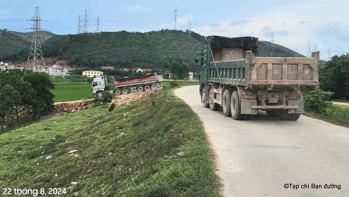 Một đoàn xe đầu kéo (6 trục) khác thì chạy trên đê và rẽ lối khác với khúc cua rộng để vào mỏ đất Quý Long nhập hàng.