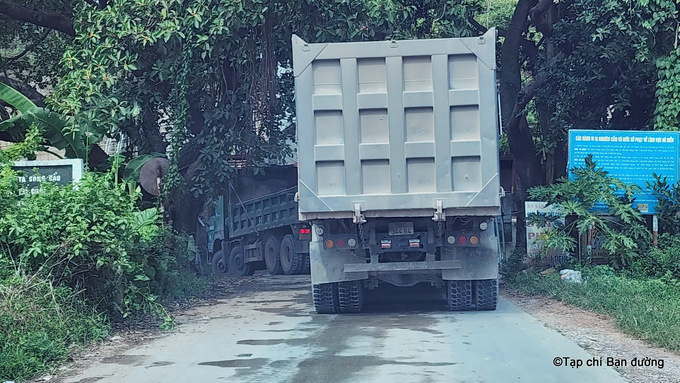 Một đoàn xe 'bốn chân thùng cao' nườm nượp chạy trên đê tả Cầu - đoạn thuộc địa phận Trúc Tay - Vân Trung - Việt Yên để vào điểm mỏ của Công ty CP Đầu tư và phát triển Quý Long (mỏ đất Quý Long) chở đất san lấp.