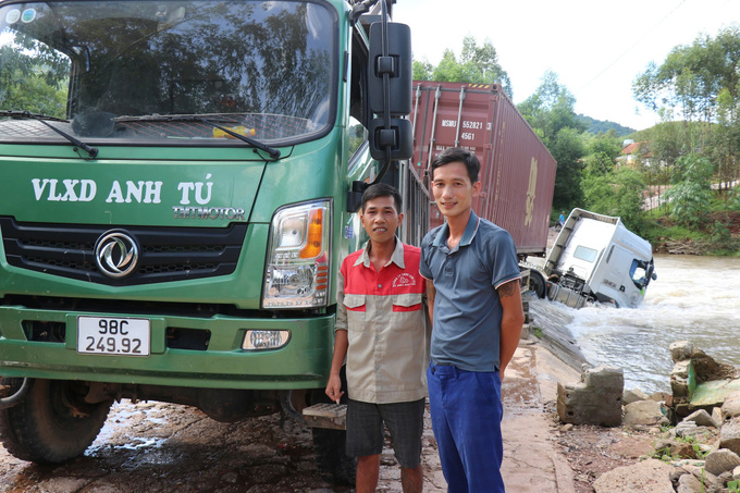 Anh Nguyễn Văn Liên (áo đỏ) và anh Nguyễn Văn Tú tại hiện trường sau khi nhảy xuống sông cứu tài xế xe đầu kéo trong dòng lũ.