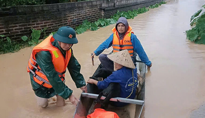 Lực lượng chức năng huyện Sơn Động hỗ trợ người dân di chuyển tài sản ra khỏi vùng ngập lụt.