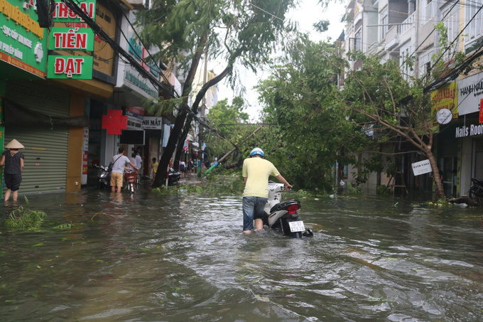 Nước ngập sâu, cây xanh, cột điện gãy đổ trên đường Hàng Kênh (quận Lê Chân) khiến các phương tiện lưu thông gặp khó khăn. Ảnh: Đinh Huyền.