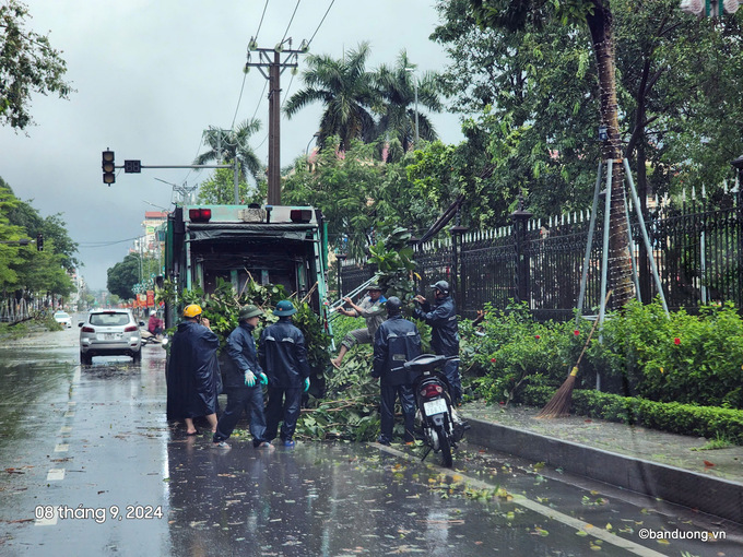 Công nhân Công ty Quản lý công trình đô thị Bắc Giang đang khẩn trương thu dọn cây đổ gẫy tại khu vực ngã 4 Hùng Vương- Hoàng Văn Thụ sáng 08/9. (Ảnh: Đặng Nam)