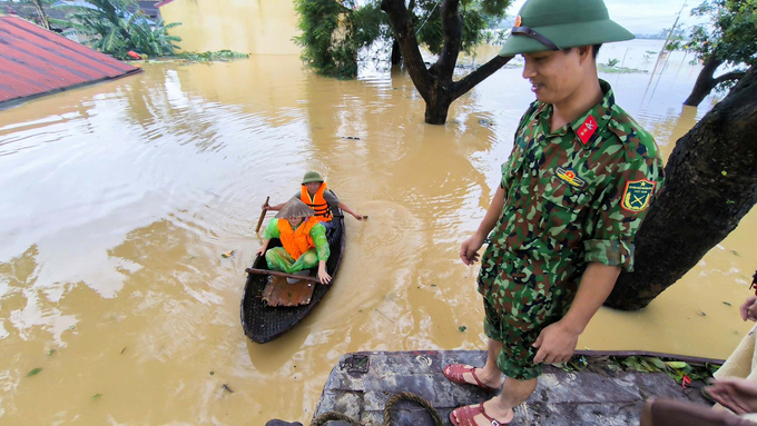 Lực lượng chức năng dùng thuyền nhỏ để đi vào các ngõ đưa người dân ra ngoài.