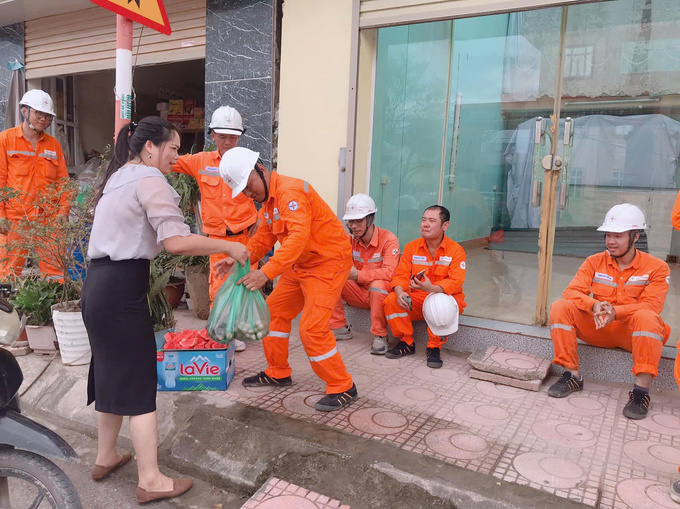 Người dân trên địa bàn phường Tân An, thị xã Quảng Yên, Quảng Ninh, tiếp nước cho kỹ thuật điện làm nhiệm vụ khắc phục điện