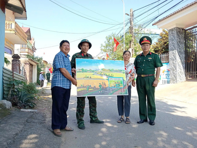 Thượng tá Đào Duy Hà- Phó Chủ nhiệm Chính trị Sư đoàn 3 trao tặng cho thôn Ngọc Sơn, xã Quang Thịnh bức tranh “Làng quân, dân- Kết nghĩa tình”.