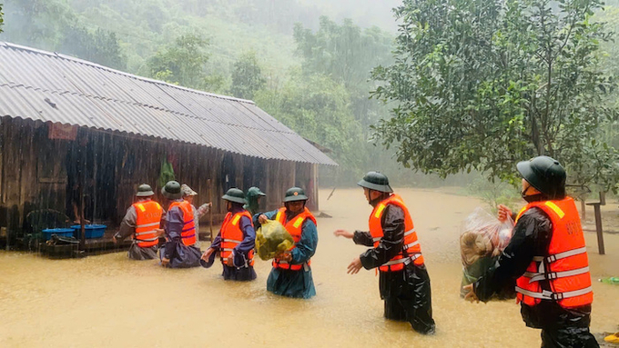 Lực lượng chức năng hỗ trợ người dân trong vùng ngập lụt.