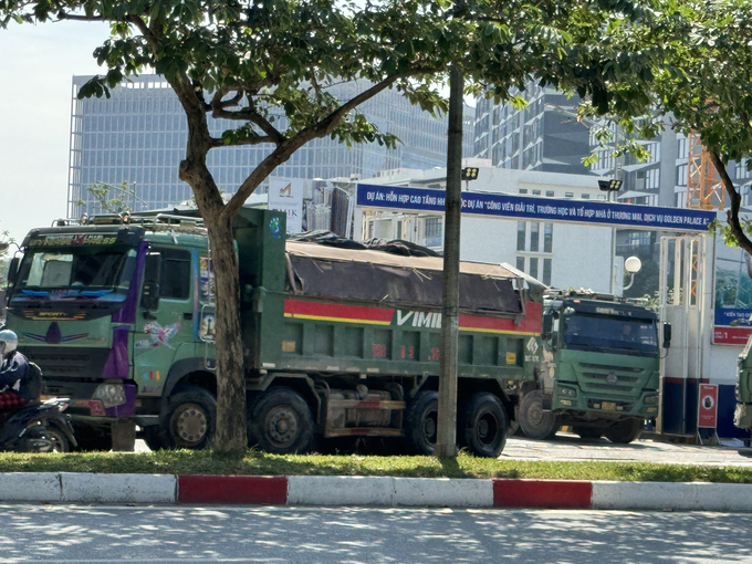 Xe tải trọng lớn chở đầy đất nối đuôi nhau di chuyển từ công trường dự án ra đường Mễ Trì.