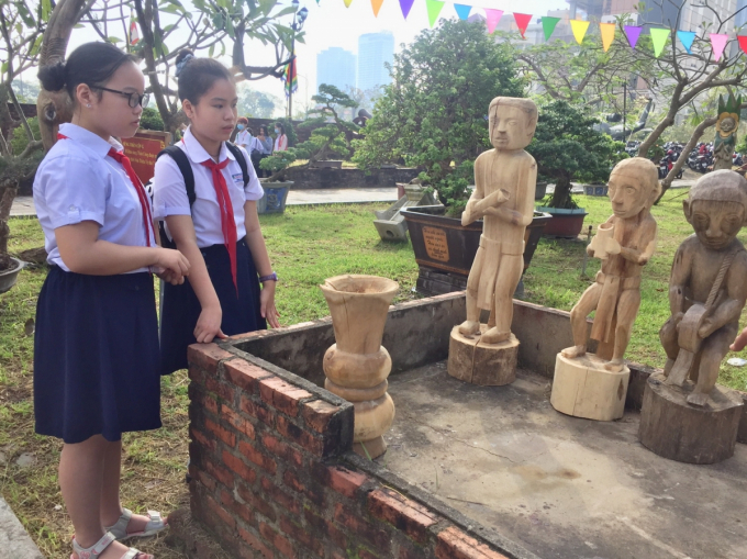 Trong ngày khai mạc, nhiều em học sinh chiêm ngưỡng tượng gỗ do nghệ nhân tài hoa người Cơ Tu tạc nên