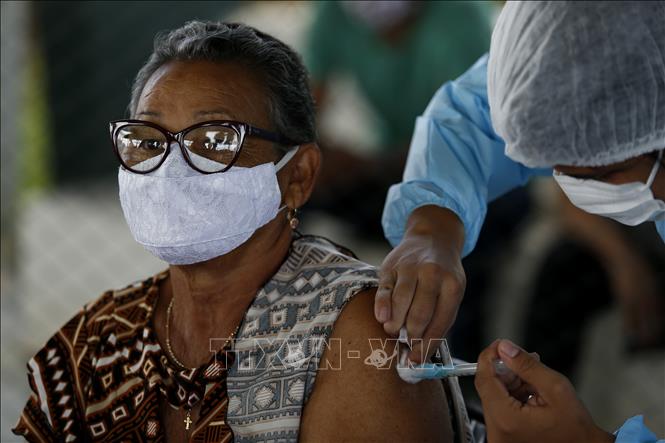 Khi đa số người dân được tiêm chủng, dịch COVID-19 được kiểm soát (Ảnh: AFP)