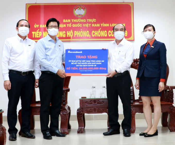 Đại diện Sacombank - ông Trần Minh Tâm, Giám đốc Chi nhánh Long An (bên trái), trao tặng 30 tỷ đồng cho Ủy ban Mặt trận Tổ quốc Việt Nam tỉnh Long An để hỗ trợ người dân khó khăn do Covid-19.