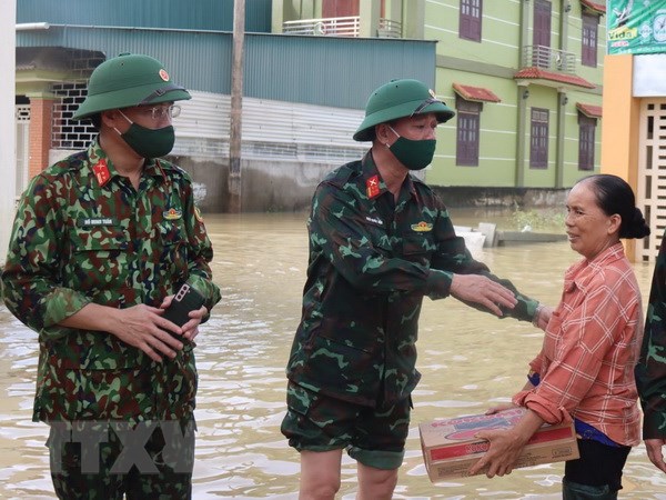 Đại diện lãnh đạo Bộ Chỉ huy Quân sự tỉnh Nghệ An trao hỗ trợ nhu yếu phẩm cho người dân xã Quỳnh Lâm, huyện Quỳnh Lưu, tỉnh Nghệ An. (Ảnh: Tá Chuyên/TTXVN)