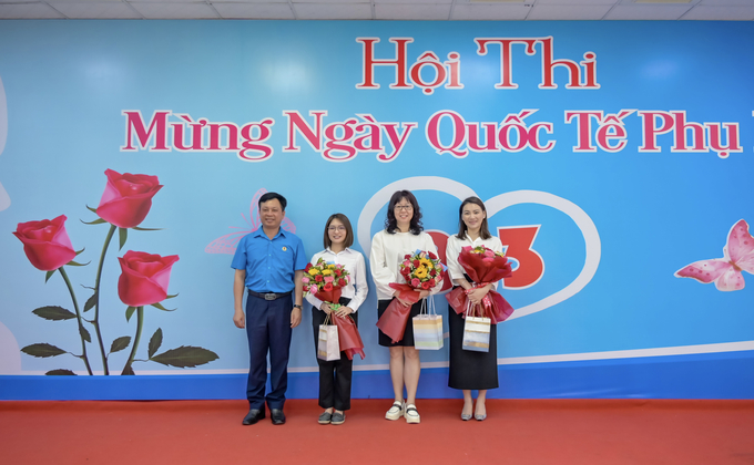 Ông Phạm Trung Thuyên - Chủ tịch Công đoàn (áo xanh) trao hoa và quà cho các nữ cán bộ nhân viên nước ngoài