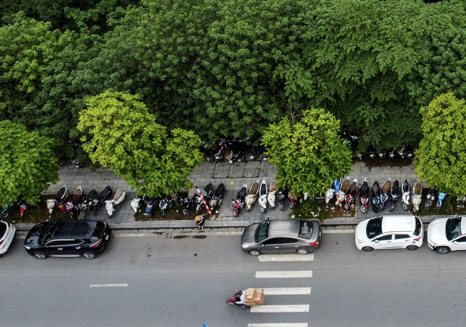 Xe máy, ô tô xếp hàng dài cả trên vỉa hè lẫn dưới lòng đường.