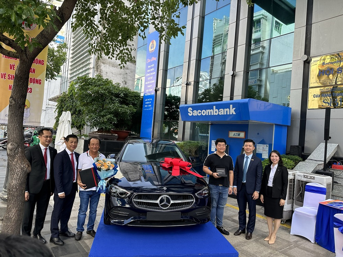 Khách hàng Võ Tấn Hoàng Minh (thứ tư từ trái qua phải) nhận giải đặc biệt ô tô Mercedes C200 vào sáng 23/5 tại trụ sở Sacombank.