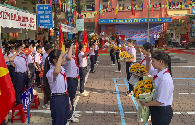 Học sinh lớp lớn tặng hoa đón các em học sinh lớp 6 bước vào năm học mới (Ảnh: Thế Sơn)