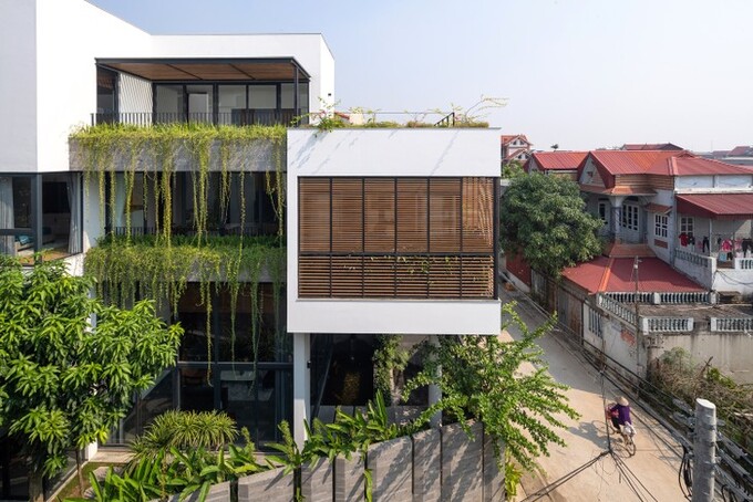Bức tường đá ong lớn được ốp khéo léo, đóng vai trò như rào cản giữa ngôi nhà và tòa nhà bên cạnh