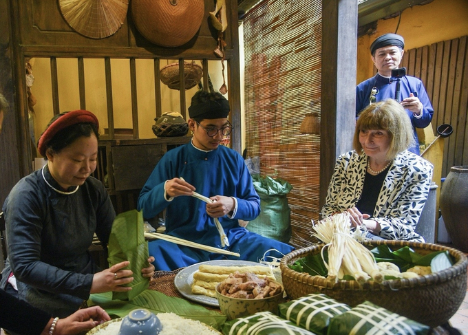 Du khách nước ngoài thích thú khi được chứng kiến trực tiếp các công đoạn gói bánh.