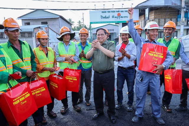 Thủ tướng đi thăm, tặng quà các công nhân đang thi công tuyến đê kè, ứng phó biến đổi khí hậu thành phố Cần Thơ tại công trường.