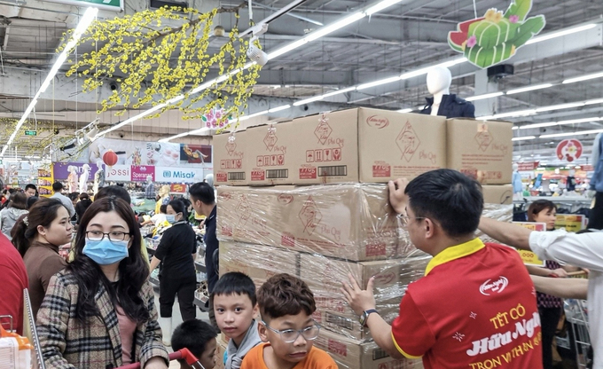 Nhân viên siêu thị liên tục bổ sung hàng hoá lên kệ hàng, nhất là các sản phẩm bánh, kẹo, mứt Tết.