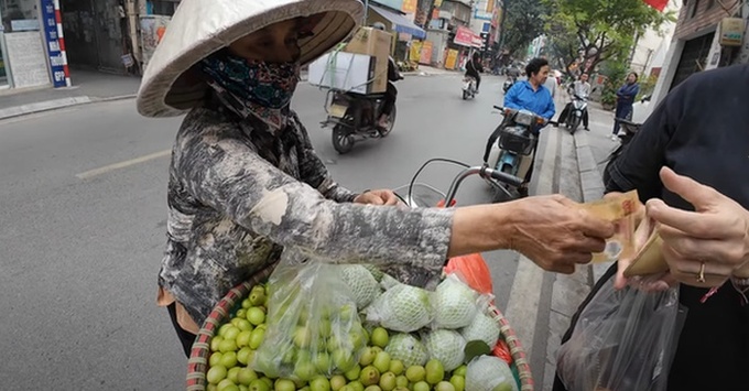 Người bán hàng rong có ý định lấy của khách nước ngoài 200.000 đồng cho một túi táo nhỏ (ảnh cắt từ clip).