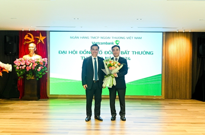 Ông Nguyễn Thanh Tùng, Chủ tịch HĐQT Vietcombank (bên trái) tặng hoa chúc mừng ông Nguyễn Tuấn Anh, Quyền Chánh Thanh tra, Giám sát ngân hàng thuộc Cơ quan Thanh tra, Giám sát ngân hàng - Ngân hàng Nhà nước (bên phải) được Đại hội đồng cổ đông bất thường 2024 bầu bổ sung làm thành viên HĐQT nhiệm kỳ 2023 - 2028. (Ảnh: Vietcombank).