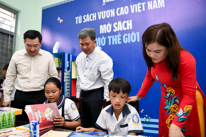 Các em học sinh khám phá tủ sách mới do Vinamilk trao tặng tại thư viện trường