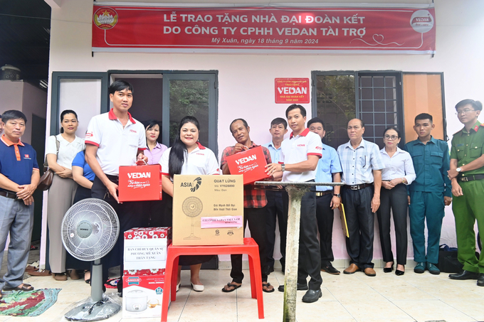 Bà Nguyễn Thu Thủy (đứng giữa) - Phó giám đốc Đối ngoại Vedan trao nhà cho gia đình anh Danh Văn Anh1