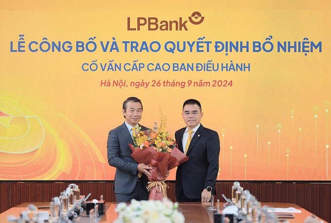 Ông Hồ Nam Tiến, Phó Chủ tịch HĐQT kiêm Tổng Giám đốc LPBank (phải) trao hoa chúc mừng ông Phạm Phú Khôi (trái).