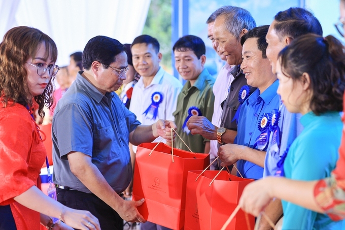 Thủ tướng Phạm Minh Chính tặng quà các đại biểu là bí thư chi bộ, trưởng thôn, già làng, trưởng bản, người có uy tín của huyện Đà Bắc .