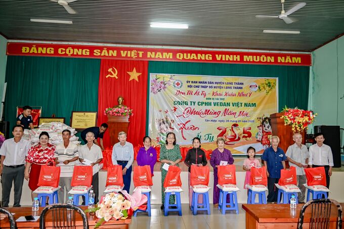 Bà Nguyễn Thu Thuỷ - Phó Giám đốc Đối ngoại Vedan Việt Nam (áo đỏ) đến trao quà Tết cho người dân tại xã Tân Hiệp