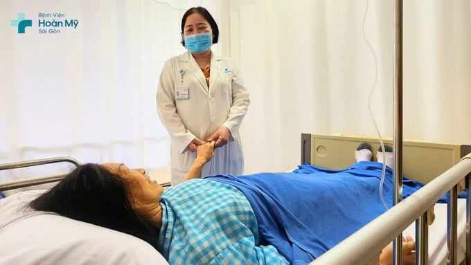 Bác sĩ thăm khám cho chị T. trước khi xuất viện.