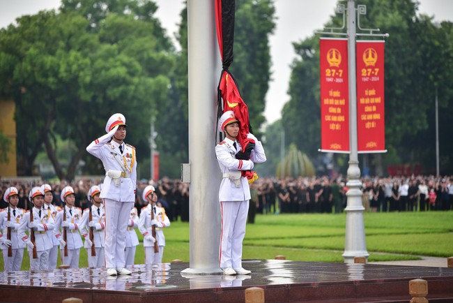  Trong quá trình Quốc kỳ được kéo lên, chiến sĩ tiêu binh vẫn ôm Quốc kỳ trước ngực.