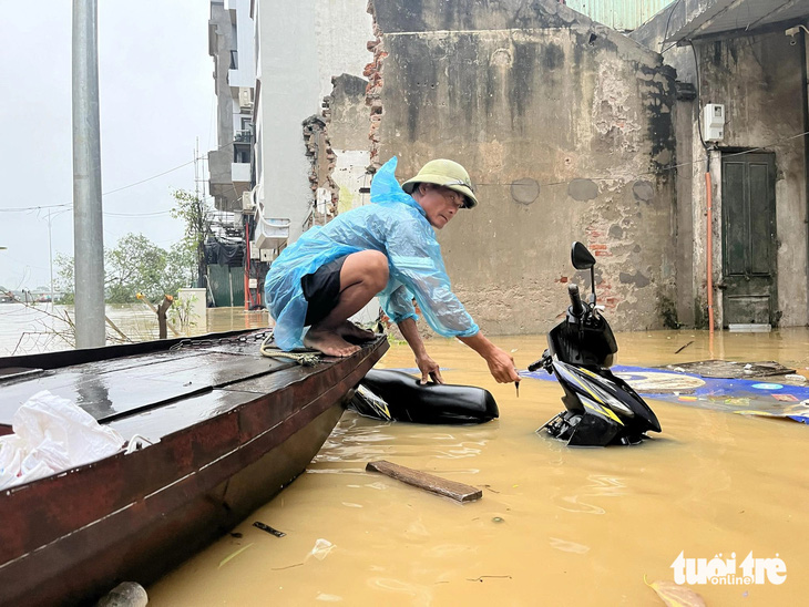  Tại phố Chương Dương Độ (quận Hoàn Kiếm), nước lũ đã dâng cao gần 1m, xe cộ gần như bị ngập, người dân phải sử dụng xuồng để di chuyển - Ảnh: NGUYỄN HOÀNG