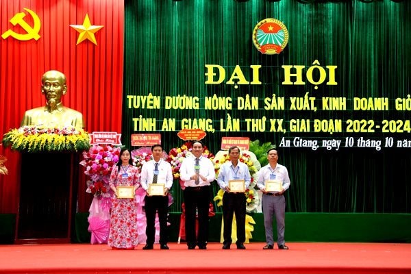  Thay mặt Ban chấp hành Trung ương Hội Nông dân Việt Nam, ông Lê Phước Dũng, Chủ tịch Hội Nông dân tỉnh An Giang, trao Kỷ niệm chương 'Vì giai cấp nông dân Việt Nam' cho 4 cá nhân - Ảnh: C.H