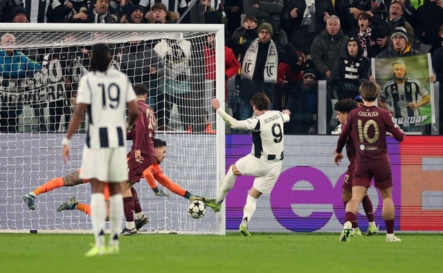 Thủ môn Ederson để vuột bóng sau cú đánh đầu của Vlahovic